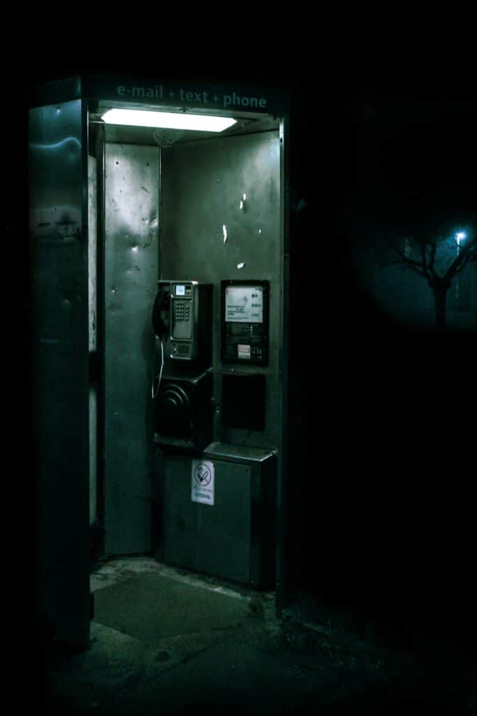 Cabina telefonica verde e nera sul marciapiede