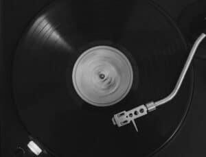 Disco in vinile nero che gira su un giradischi con braccio argentato