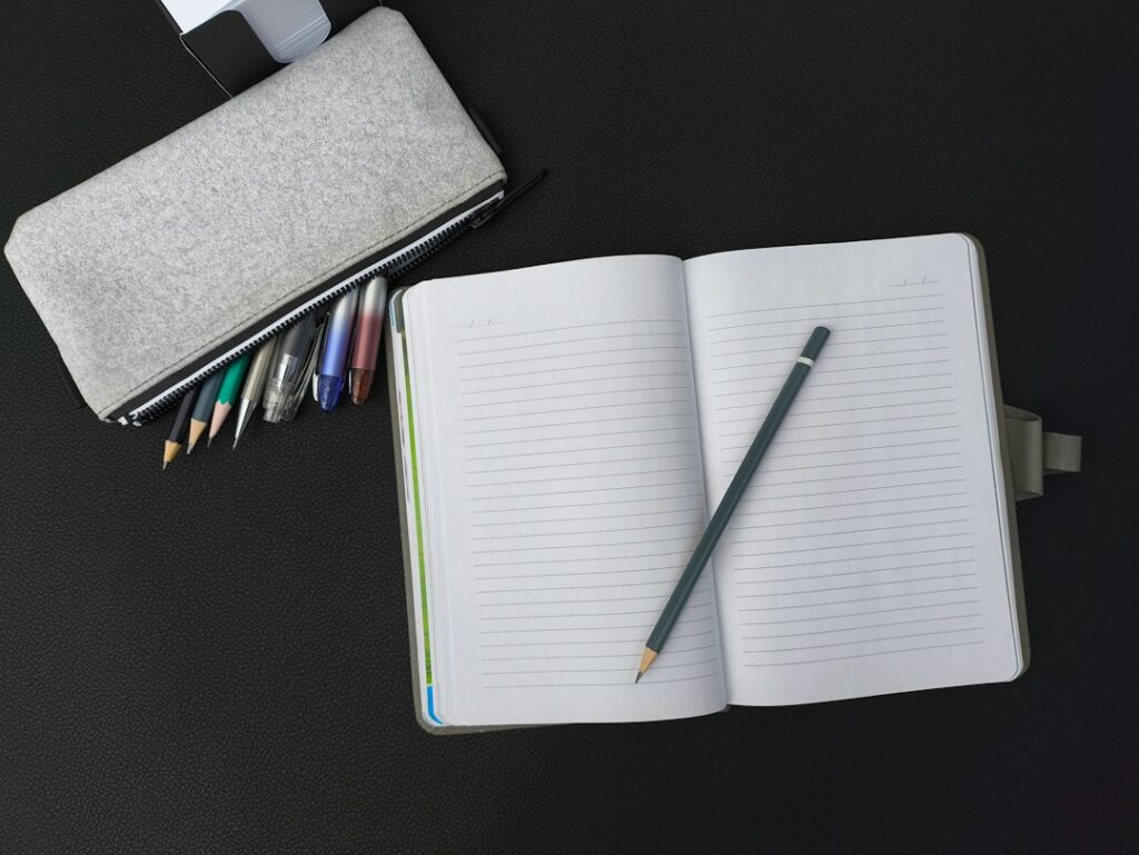 Quaderno aperto con penna e matita su un tavolo