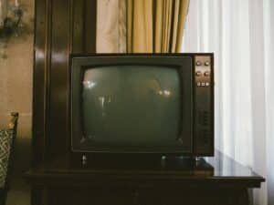 Vecchio televisore a tubo catodico grigio su un tavolo